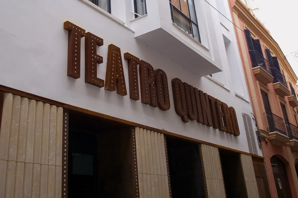 The white facade of the former Teatro Quintero on Calle Cuna in Seville, with large rust-coloured letters spelling the old theatre name above the entrance